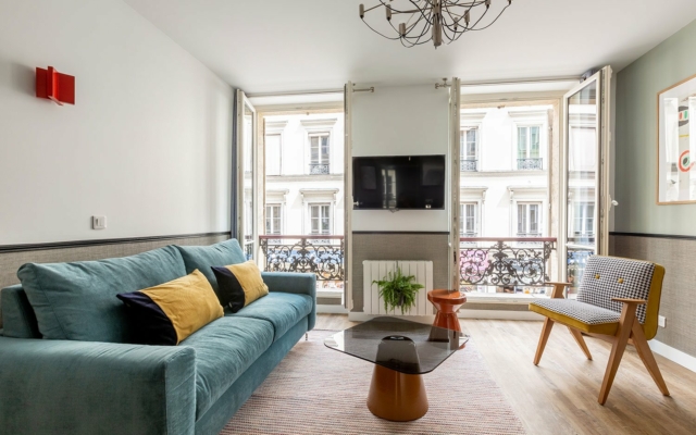 Saint-Lazare salon suites urbaines Edgar décorée dans un style cosy avec canapé et fauteuil.