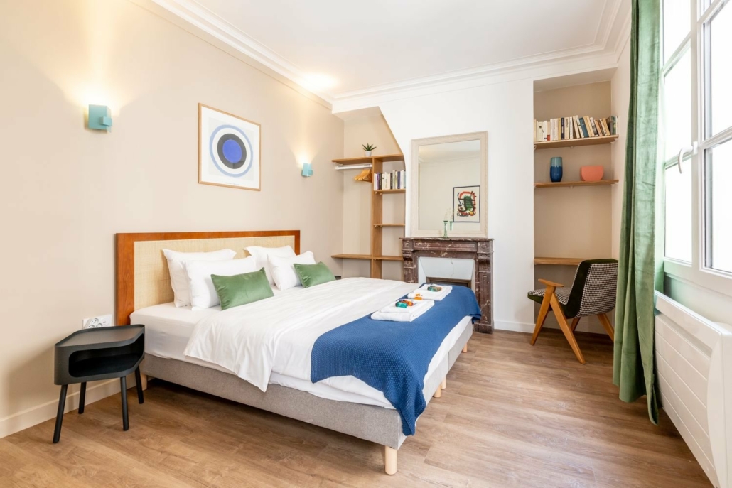 Grande chambre avec lit double et espace de travail.