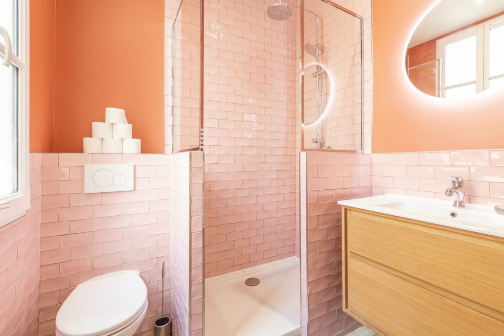 Salle de bain entièrement équipée avec cabine de douche, évier/miroir et WC.