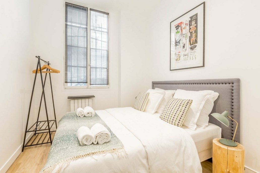 Chambre avec lit double, penderie, décoration simple et épurée.