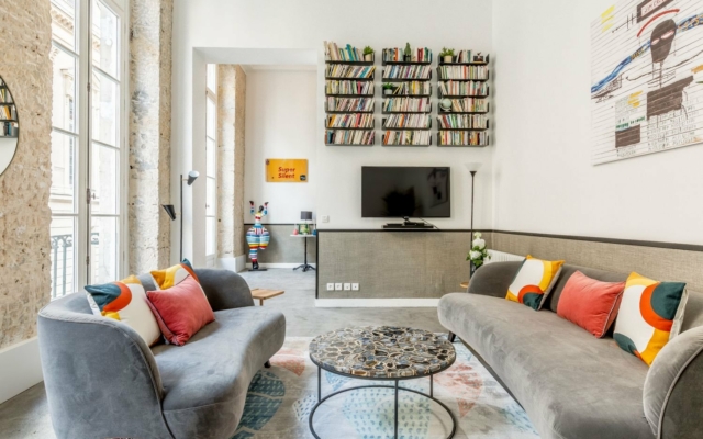 Richelieu suites urbaines trendy, salon avec 2 canapés, table basse et TV.