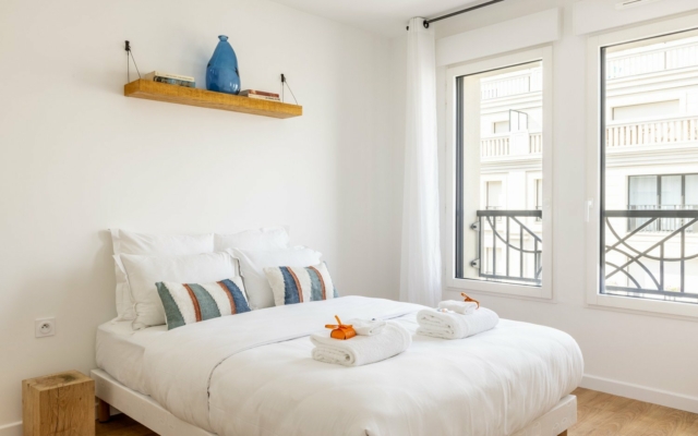 Suite à Levallois. Chambre avec lit double. Décoration épurée et soignée.