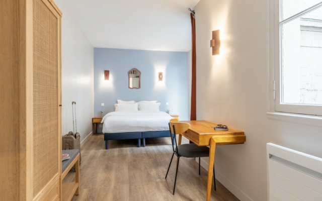 Grands Boulevards Chambre spacieuse avec lit double. Espace de travail aménagé.
