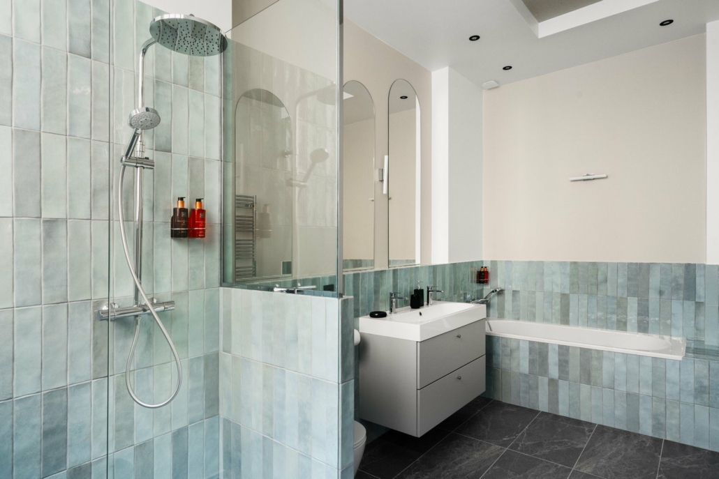 Salle de bain avec douche à l'italienne, WC et double évier.