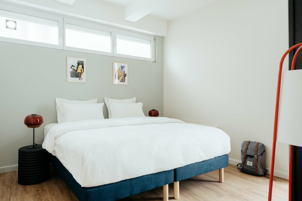 Chambre avec lit double, spacieuse et décoration épurée.