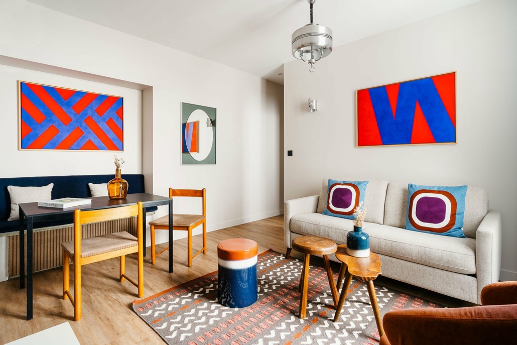Champs Elysées suites urbaines décorée dans un style cosy et tons chauds, salon avec canapé, séjour avec table à manger