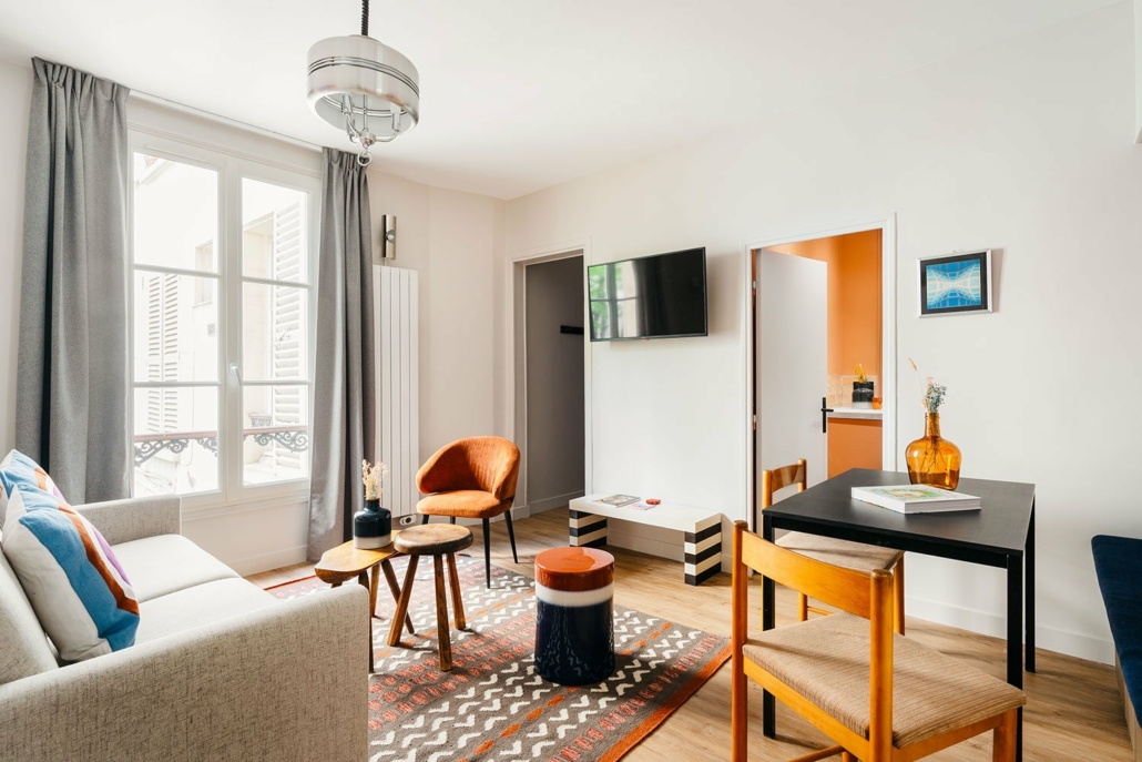 Salon spacieux avec canapé et salle à manger.