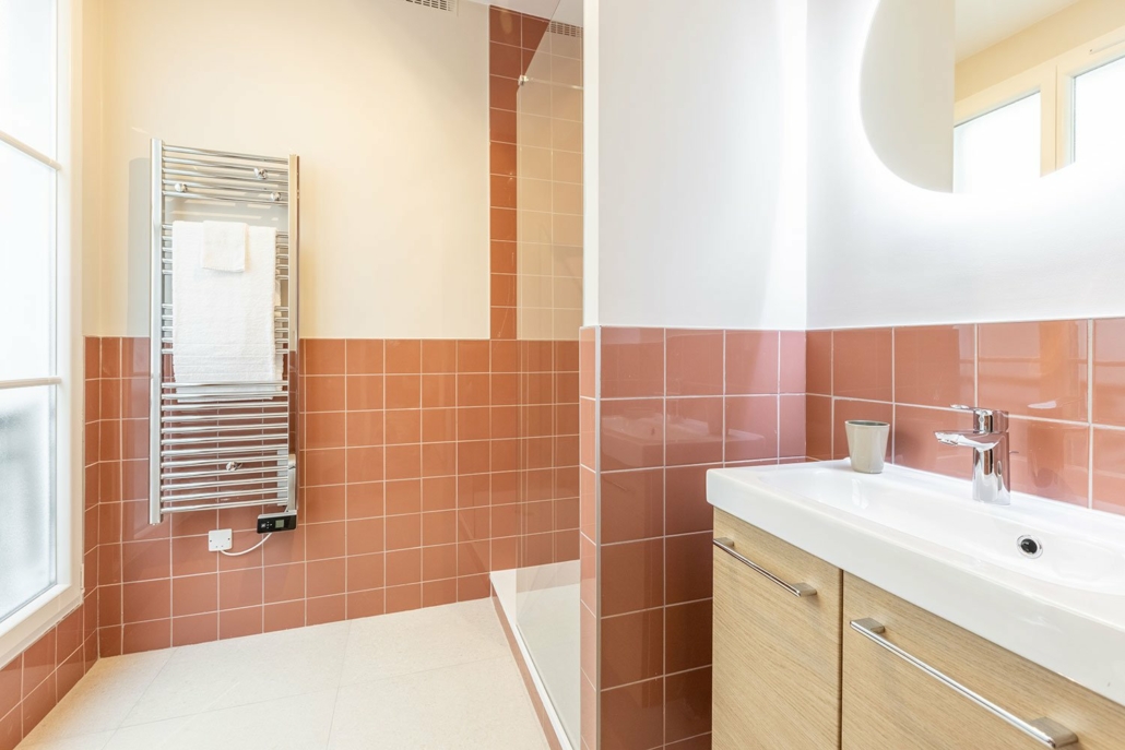 Salle de bain avec douche à l'italienne décorée dans des tons saumon