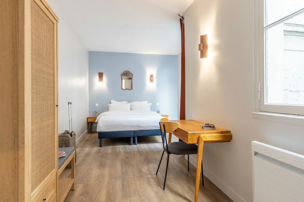suites urbaines double équipée avec bureau, décorée bois et bleu.