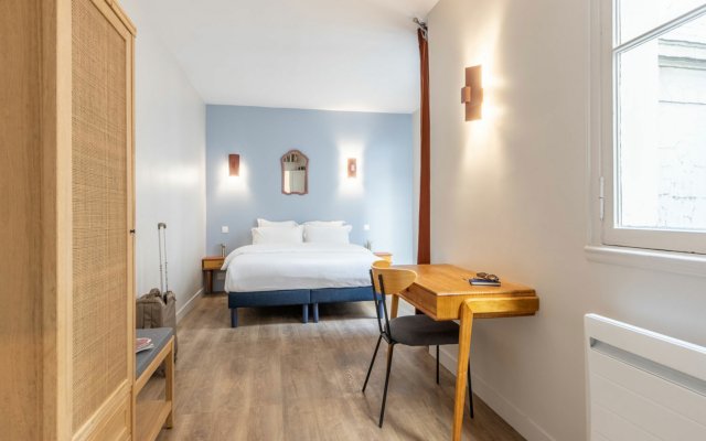 suites urbaines double équipée avec bureau, décorée bois et bleu.