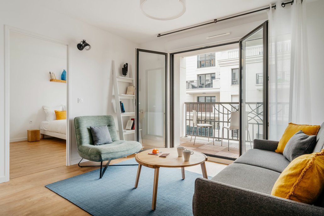 Salon avec porte fenêtre donnant sur balcon.