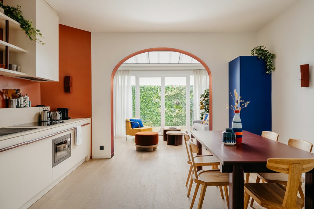 Photo panoramique suites urbaines avec cuisine équipée, table à manger et salon. Style rétro.