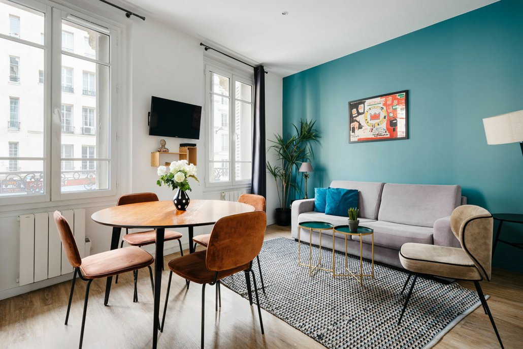 Salon avec équipement ( canapé, table à manger, TV), décorée dans un style cosy et tendance.